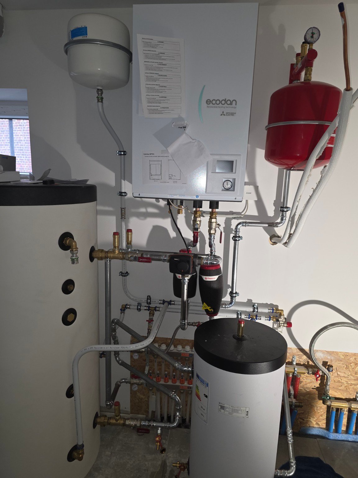 Installation intérieure Mitsubishi Electric Ecodan avec ballons et raccordements hydrauliques